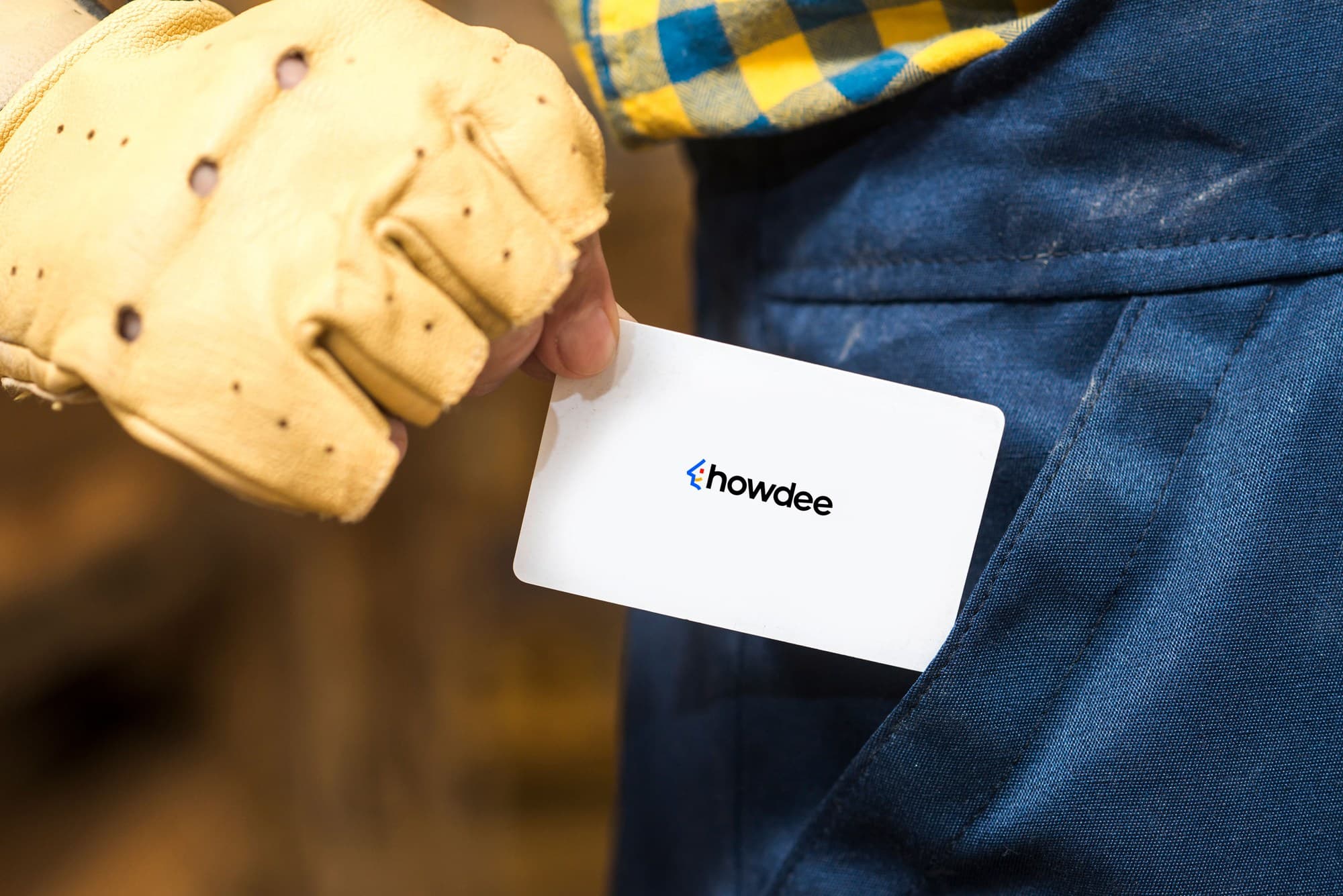 Howdee business card held by a person in work gloves