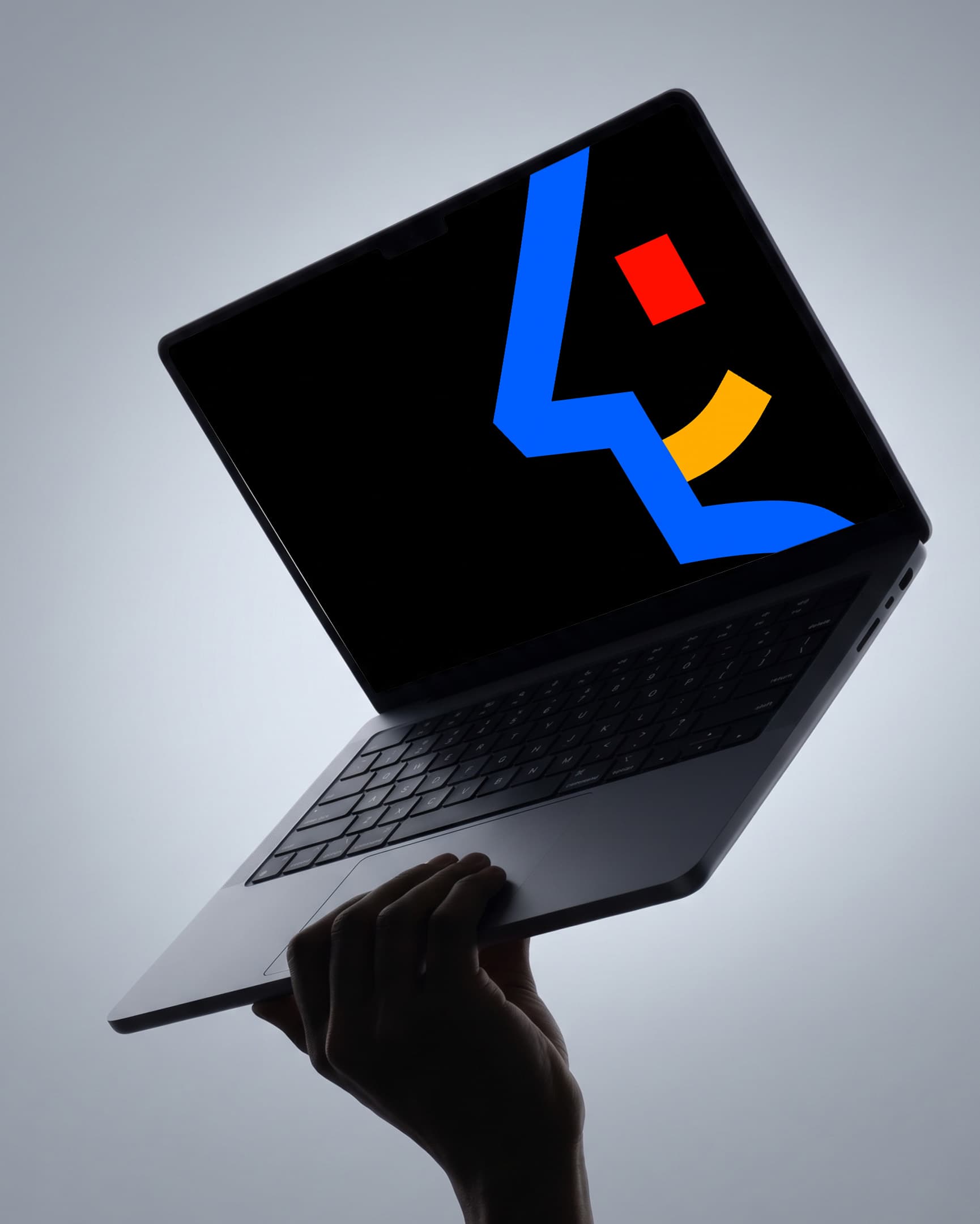 Howdee multicolour symbol on a laptop held in one hand